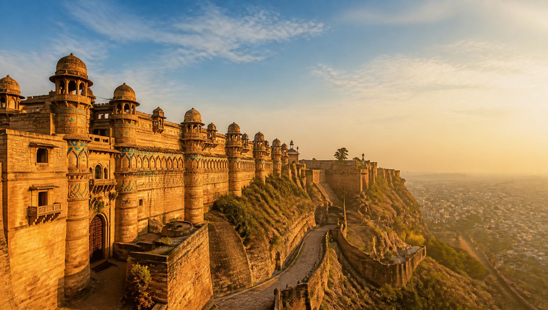 Gwalior Fort ramparts glowing in golden evening light above the city
